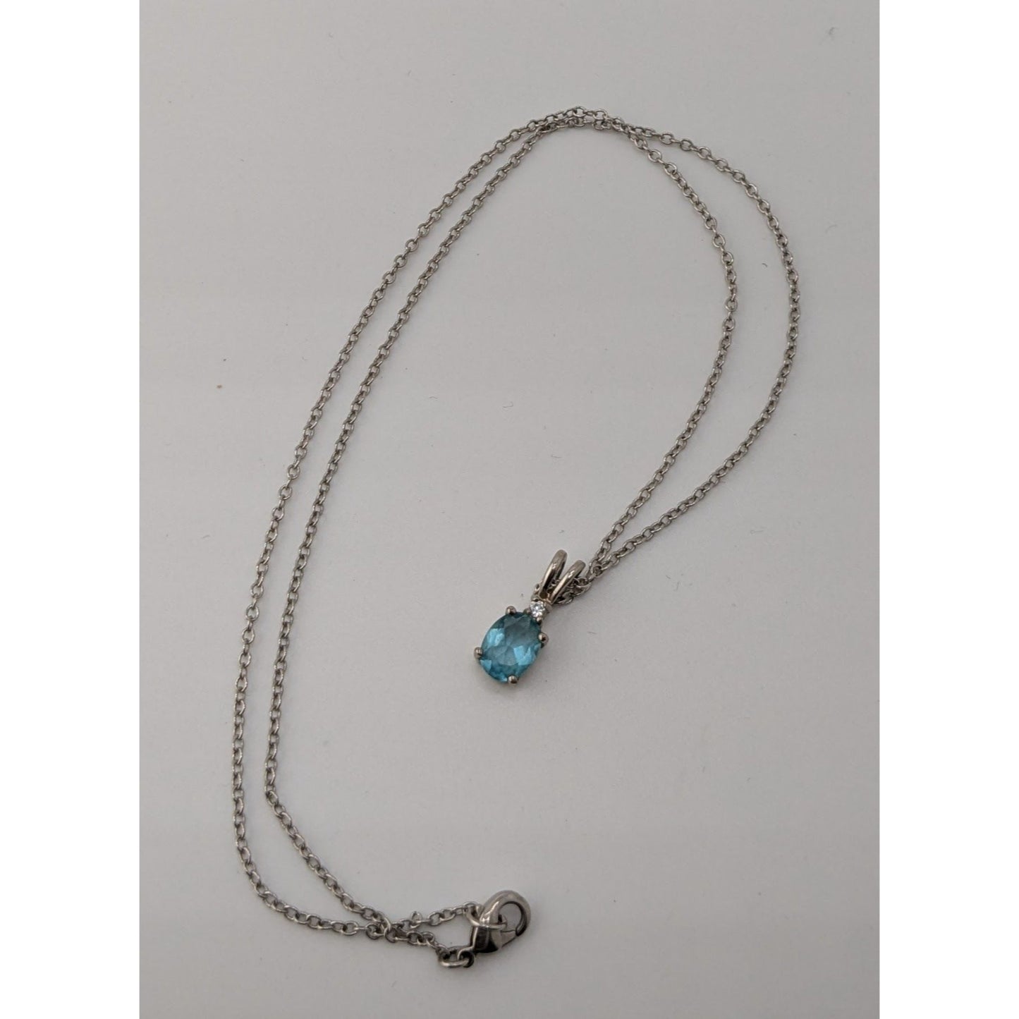 Elegant Silver Tone Necklace With Blue Topaz Oval Pendant And Clear Stone Accent